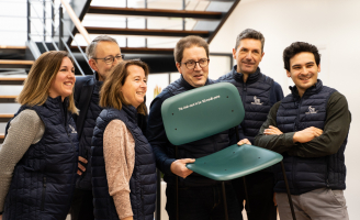 Collaborateurs Novo Nordisk portant une chaise créée avec des stylos d'insuline dans le cadre du projet "Returpen"