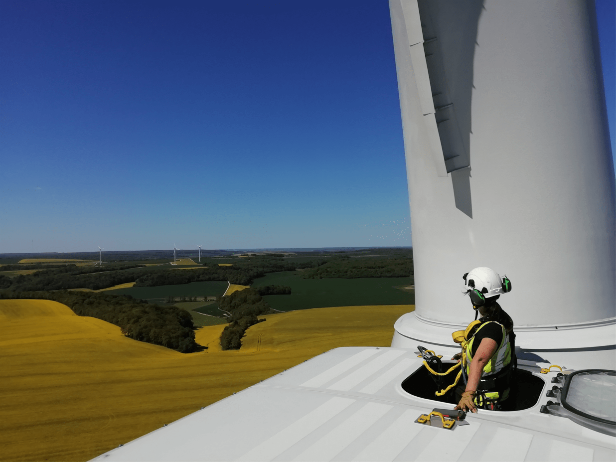 Une collaboratrice en pleine inspection d'une éolienne.